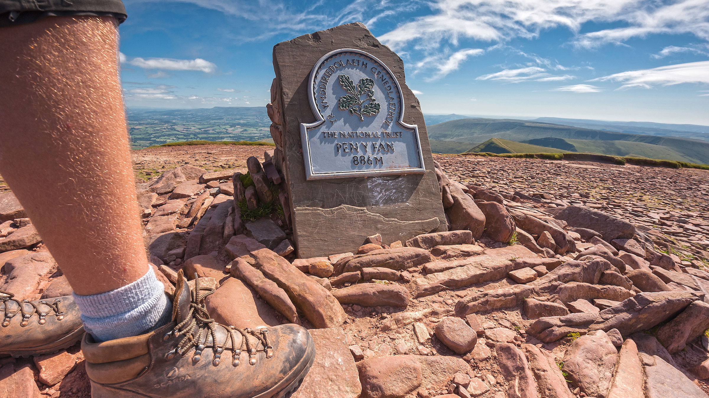 A hiker summits Pen y Fan, the highest peak in South Wales